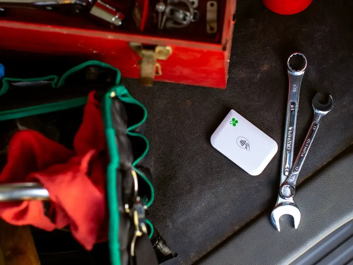 Portable card reader on a workbench beside wrenches and a toolbox