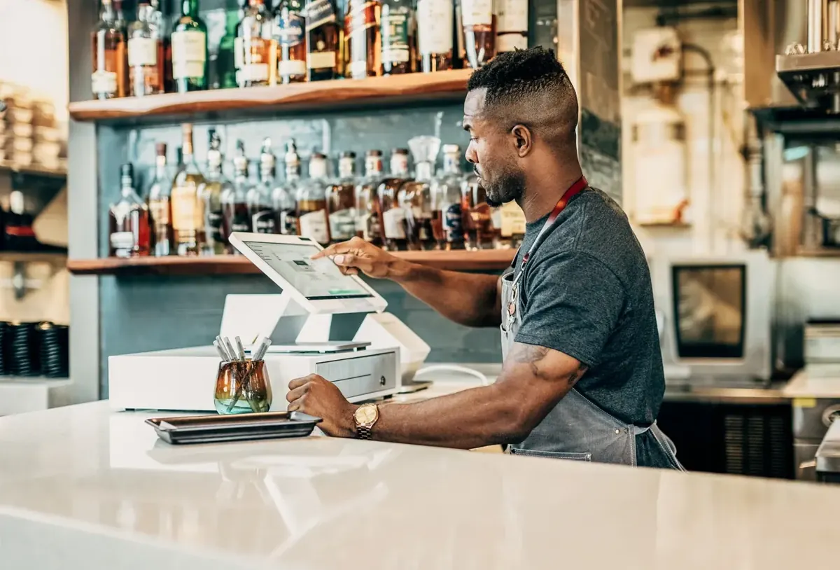 Bartender using a countertop POS station at a hotel-style bar